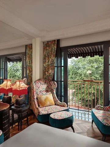 Elegantes Hotelzimmer mit Sitzbereich und dekorativem Balkon