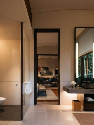 Elegantes Badezimmer mit Spiegeln und Blick in einen gemütlichen Wohnbereich