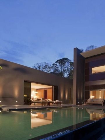 Moderne Villa bei Nacht mit beleuchtetem Pool