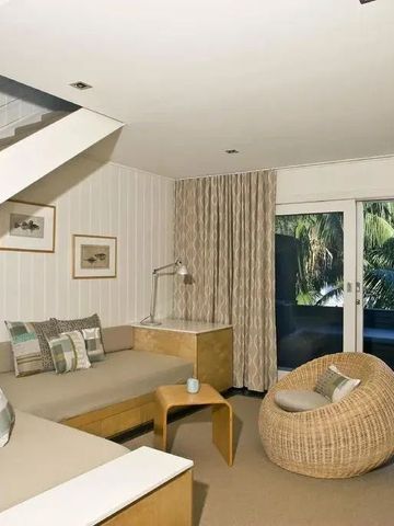 Gemütlicher Wohnbereich in Hotelzimmer mit Treppe und moderner Einrichtung