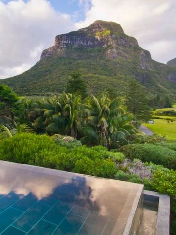 Infinity Pool mit Blick auf grüne Hügel und einen Berg