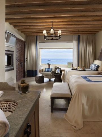 Geräumiges Zimmer mit Doppelbetten und Meerblick vom Fenster.