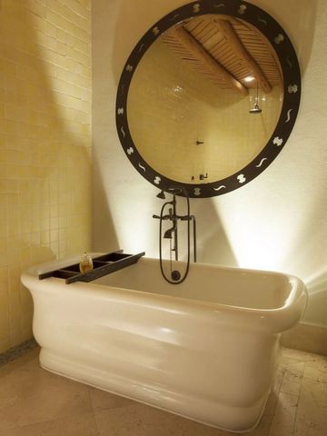 Luxuriöses Badezimmer mit stilvoller freistehender Badewanne und großem Spiegel