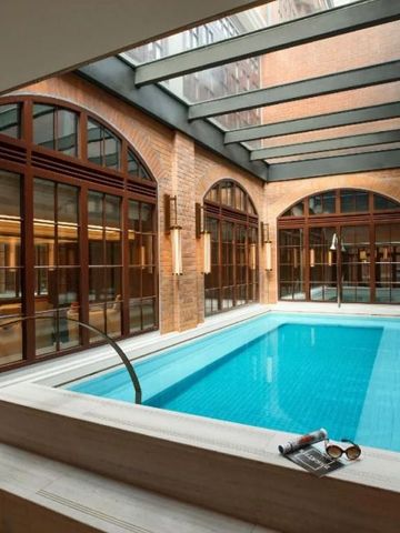 Luxuriöser Innenpoolbereich mit Glasdach und Brick-Elementen