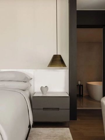 Minimalistisch gestaltetes Schlafzimmer mit angrenzendem Badezimmer.