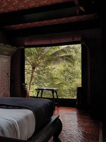 Elegantes Schlafzimmer mit großen Fenstern und üppigem Waldblick