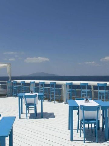 Dachterrasse mit blauen Stühlen und Meerblick auf Capri