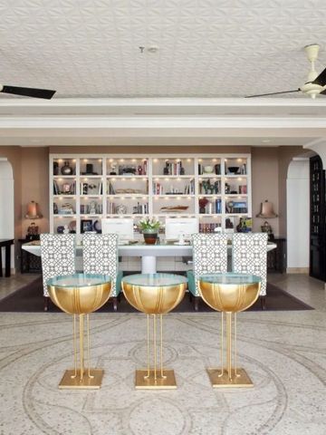 Elegante Lobby des Capri Tiberio Palace mit goldenen Barhockern und kunstvoller Decke