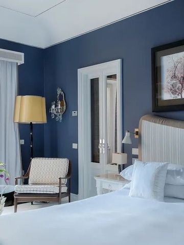 Modernes Zimmer mit blau gestrichenen Wänden und stilvoller Einrichtung im Capri Tiberio Palace