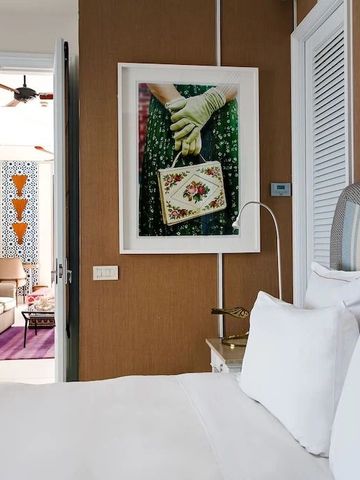 Hotelzimmer mit Blick auf offenen Wohnbereich und kunstvolles Wandbild