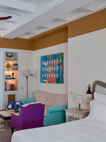 Luxuriös eingerichtetes Zimmer mit farbenfrohem Sofa und moderner Kunst