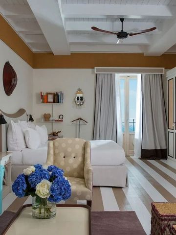 Helles, modern eingerichtetes Hotelzimmer mit Doppelbett, gemütlichen Sitzgelegenheiten und großer Fensterfront.