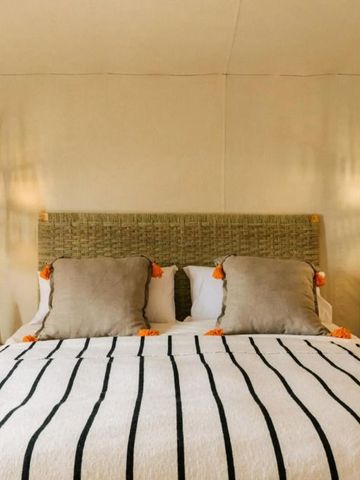 Helles Zeltzimmer mit gestreifter Decke und stilvollen Lampen im Caravan Agafay