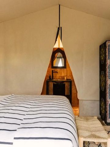 Stilvoll eingerichtetes Zeltzimmer mit traditionellem Schrank im Caravan Agafay