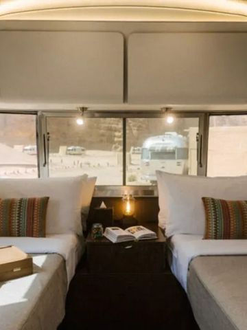 Doppelbettzimmer mit Fensterblick in einem eleganten Wohnwagen