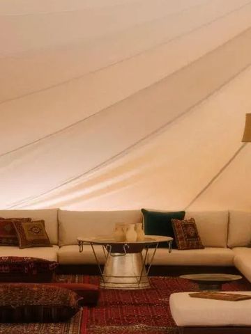 Luxuriöses Lounge-Zelt mit komfortabler Sitzgruppe und warmem Ambiente