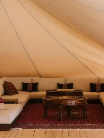 Gemütliches Sitzbereich im Zelt mit traditionellen Teppichen und Kissen