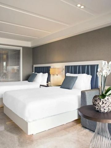 Geräumiges Zimmer mit zwei Doppelbetten und eleganter Gestaltung im modernen Design