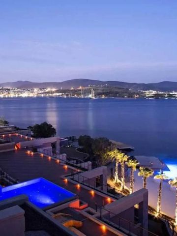 Panoramablick auf beleuchteten Infinity-Pool und Hafen bei Nacht