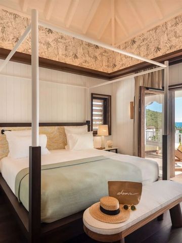 Schlafzimmer mit Himmelbett und Zugang zum Balkon mit Meerblick