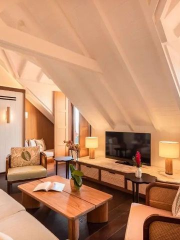 Wohnbereich unter Dachschräge mit gemütlichen Sitzgelegenheiten und Fernseher