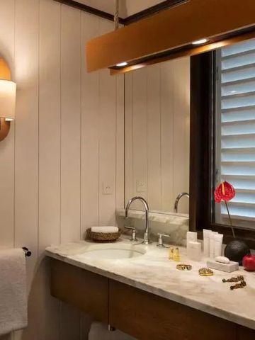 Elegantes Badezimmer mit Holzdetails und Marmorelementen im Hotel