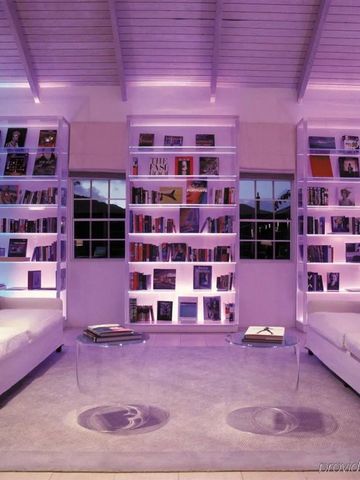 Moderne Bibliothek mit lila Beleuchtung und gemütlichen Sofas