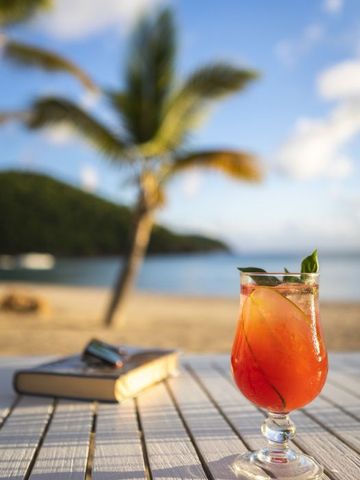 Erfrischender Cocktail am Strand mit Palmen im Hintergrund