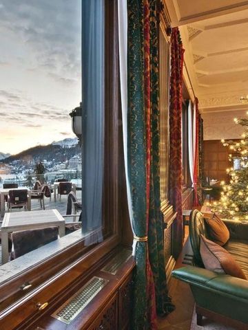 Gemütlicher Lounge-Bereich mit Blick auf die verschneiten Berge und Weihnachtsdekoration