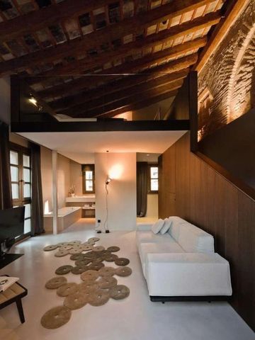 Moderne Suite im Caro Hotel mit stilvollem Interieur und rustikalem Holzbalken an der Decke