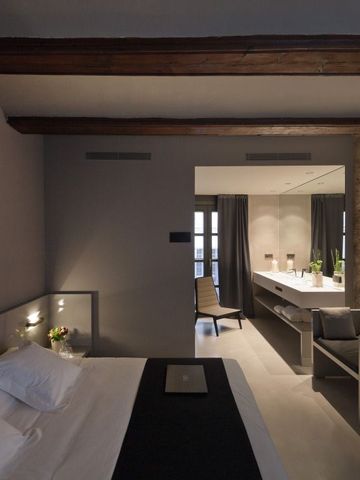 Komfortables Schlafzimmer im Caro Hotel mit rustikalen Steinwänden und modernem Mobiliar