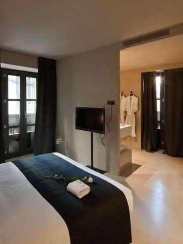 Gut ausgestattetes Hotelzimmer mit Doppelbett und Blick ins Badezimmer