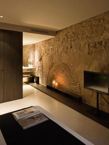 Hotelzimmer mit sichtbarer Ziegelsteinwand und moderner Beleuchtung