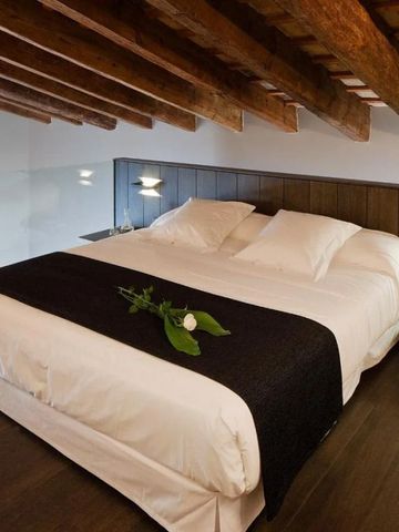 Hotel Schlafzimmer mit Holzbalkendecke und luxuriösem Bett