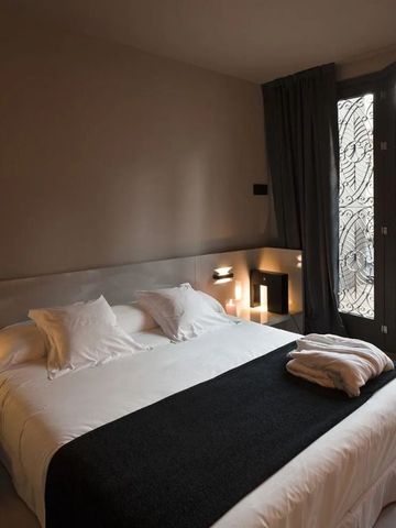 Gemütliches Hotelzimmer mit Doppelbett und dekorativem Fenster mit Kunstmotiven