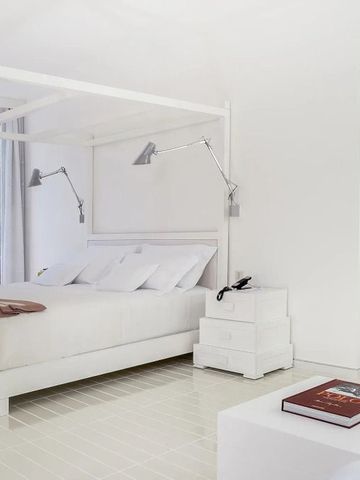 Helles, minimalistisches Zimmer mit einem Himmelbett und einem großen Spiegel