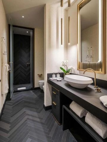 Modernes Badezimmer mit Waschbecken und großen Spiegeln in einem Hotel.