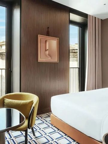 Helles Zimmer mit großen Fenstern und Blick auf die Stadt