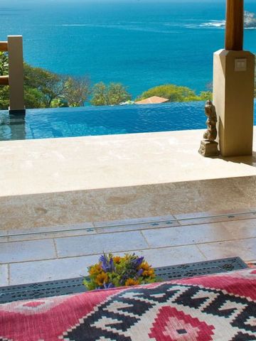Infinity Pool mit Blick auf das Meer und tropische Vegetation