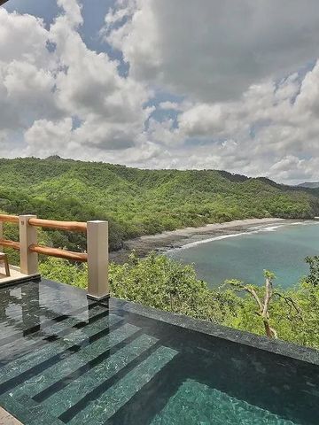 Privater Infinity-Pool mit Blick auf bewaldete Küste und meeresblauen Himmel