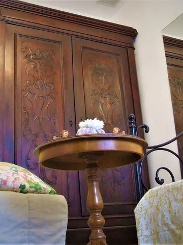 Sitzbereich mit antikem Schrank und Tisch