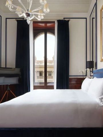 Elegantes Schlafzimmer mit klassischer Dekoration und großen Fenstern