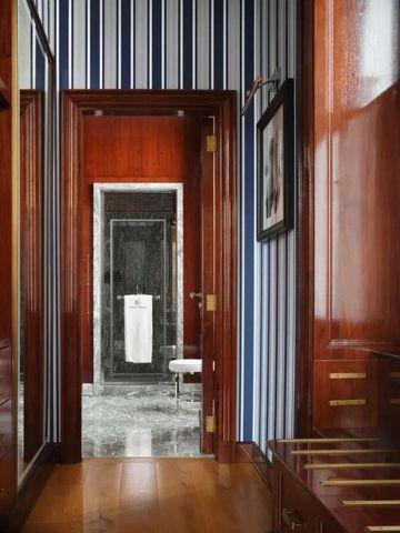 Eleganter Flur mit dunklen Holztüren zu einem modernen Badezimmer