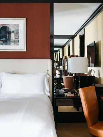 Komfortables Hotelzimmer mit Doppelbett, Wandkunst und Schreibtischbereich