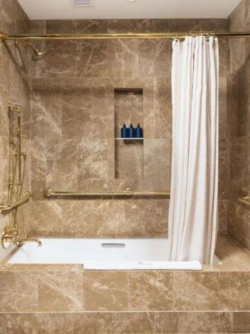 Luxuriöses Badezimmer aus Marmor mit Badewanne und Duschvorhang