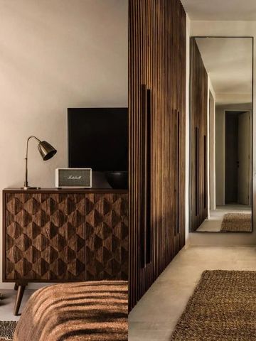 Hotelzimmer mit eleganter Holzeinrichtung und großem Spiegel