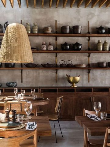 Restaurant mit rustikalem Holzmobiliar und Wandregalen mit Töpferwaren