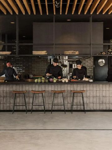 Offene Küche mit modernen Elementen und mehreren Köchen an der Theke