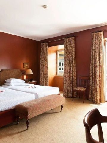 Gemütliches Hotelzimmer mit klassischem Doppelbett und Balkonzugang