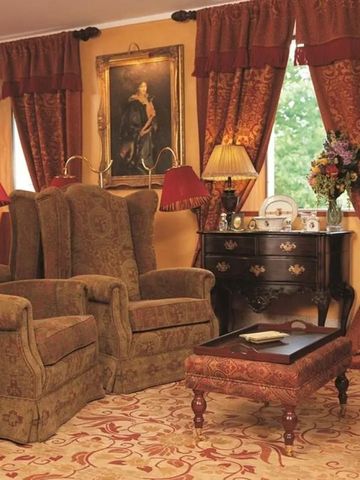 Eleganter Wohnbereich mit antiken Möbeln und luxuriösen Gardinen